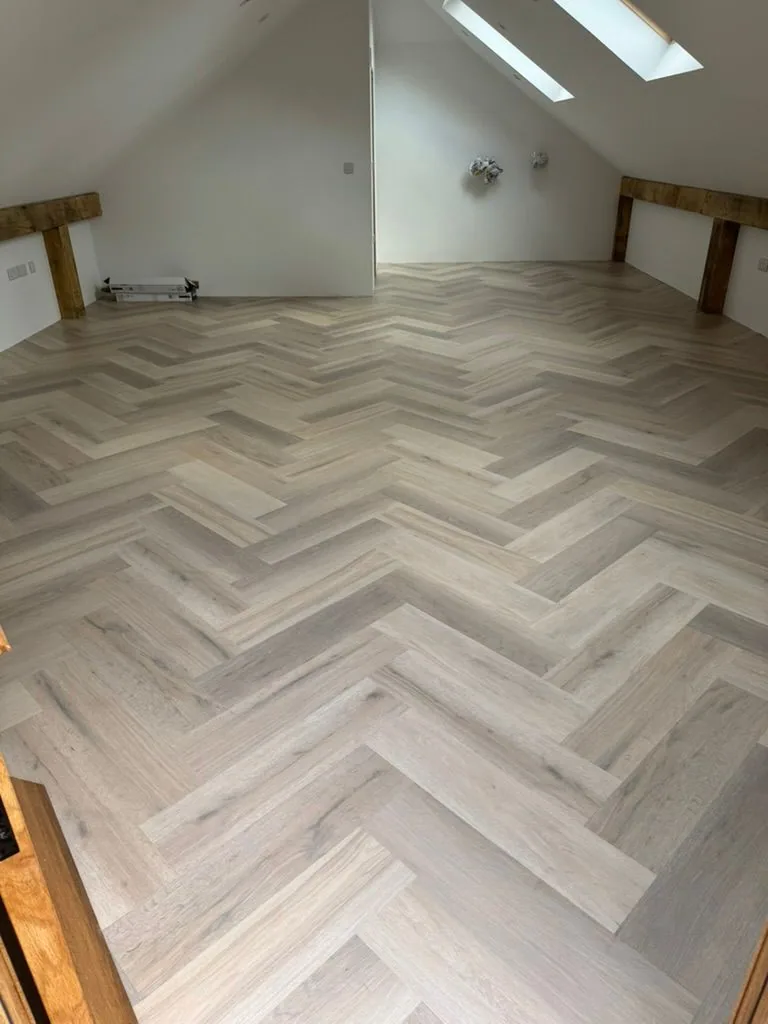 Wide view of annex herringbone Karndean floor under sloped ceiling with skylights
