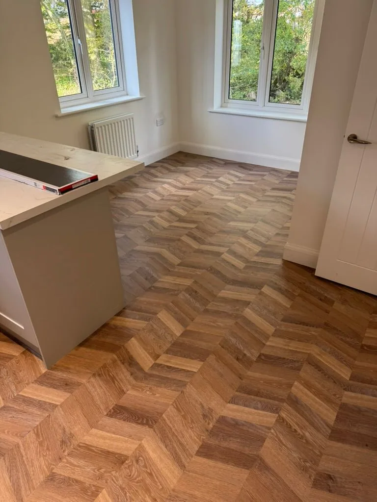 Warm oak chevron Karndean Knight Tile flooring in a bright ground-floor room with white walls and natural light
